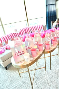 a table with pink cups and candy on it