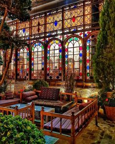 a room filled with lots of furniture and windows covered in stained glass window panes