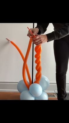 a woman is holding an orange balloon in her hand