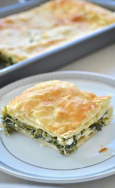 a piece of quiche sitting on top of a white plate next to a pan