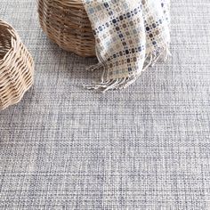 a basket and blanket sitting on top of a rug