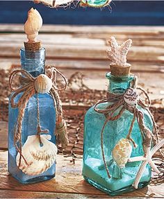 two glass bottles with seashells in them