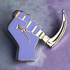 a lapel pin with a purple fist on it