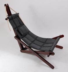 a black leather chair sitting on top of a wooden stand