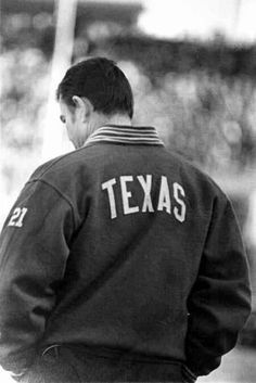 a black and white photo of a man wearing a jacket that says texas on it