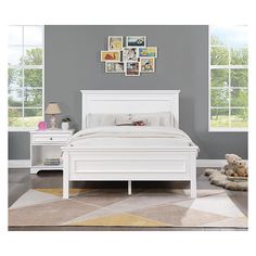 a white bed sitting in a bedroom on top of a floor next to a window