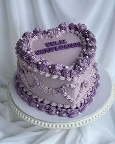 a heart shaped cake with purple frosting on top