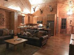 a living room filled with furniture and wooden walls