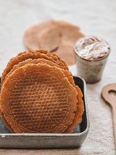 several waffles in a metal container next to a cup of icecream