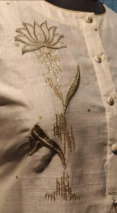 an embroidered shirt with gold thread work on the front and back, along with sequins