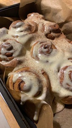 a pan filled with cinnamon rolls covered in icing