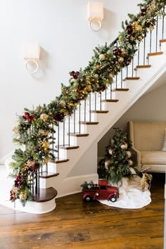 a christmas garland on the banister next to a stair case