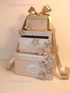 three boxes stacked on top of each other with bows and ribbons around the bottom one