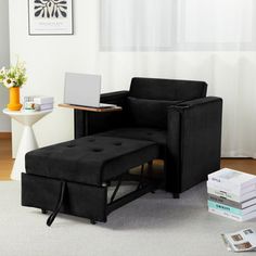 a living room with a chair, ottoman and laptop computer on the table next to it