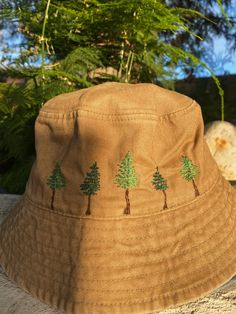 a brown hat with trees on it sitting next to some rocks and plants in the background