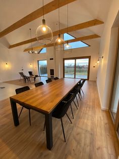 a large wooden table sitting in the middle of a living room with lots of windows