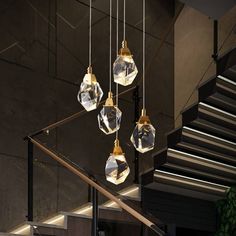 some glass balls hanging from the ceiling in front of a stair case with lights on it