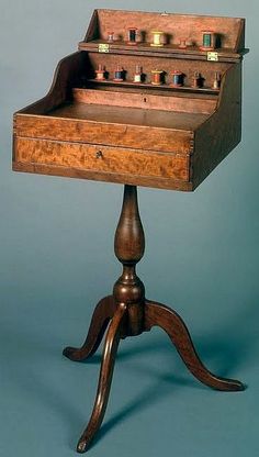 an old wooden desk with drawers on it's legs and two candles in the drawer