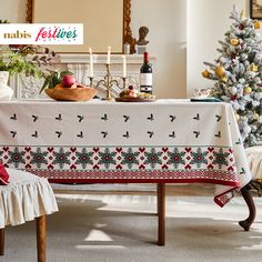 a table covered with a white cloth next to a christmas tree