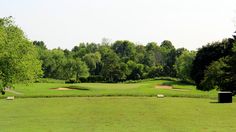 a golf course surrounded by trees and grass