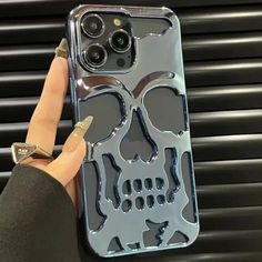 a person holding up a phone case with a skull on it