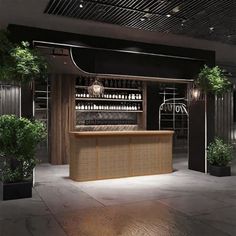 an empty bar in the middle of a room with potted plants on either side