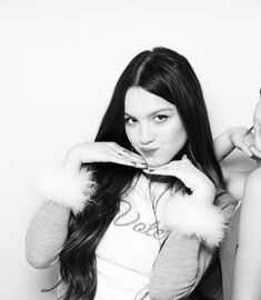 two women are posing for a black and white photo, one is holding her hair in the other's hand