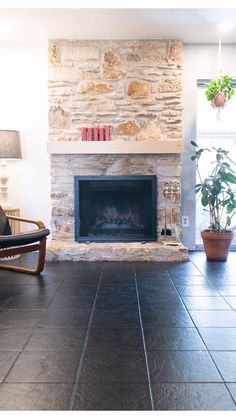 a living room with a stone fireplace and chairs