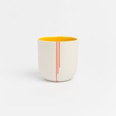 a white and orange cup sitting on top of a table