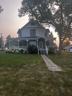 a white house sitting on top of a lush green field