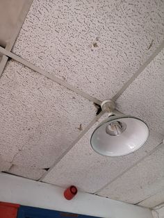 a ceiling light that has been damaged and is hanging from the ceiling in an empty room