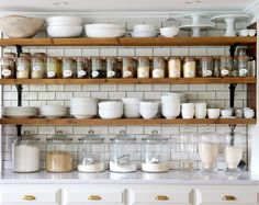 the shelves are filled with jars and bowls