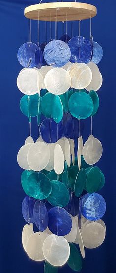 a wind chime made out of sea glass with blue and white discs hanging from it