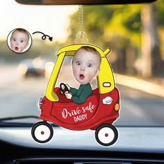 a baby in a red car with the words drive safe daddy hanging from it's front window