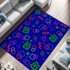 a blue area rug with colorful shapes and lines on the floor next to a couch