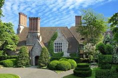 a large house with hedges in front of it and a driveway leading to the entrance