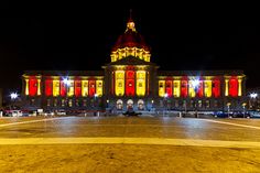 a large building lit up at night with red and yellow lights