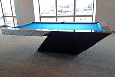 a pool table in the middle of a room with large windows and floor to ceiling carpeting