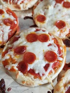 small pepperoni pizzas are sitting on wax paper