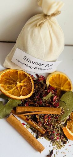 an assortment of spices and herbs on a white surface with a bag in the background