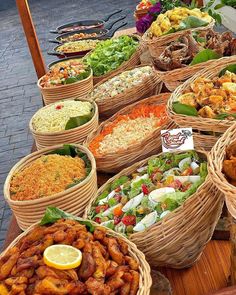 many baskets filled with different types of food on top of a wooden table next to each other