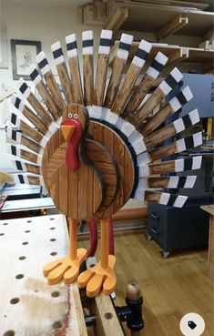 a wooden turkey with orange feet on a table