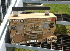 a cardboard boombox sitting on top of a metal grate