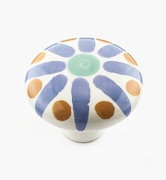 a ceramic door knob with blue, orange and white designs