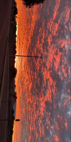 the sun is setting over the water and clouds