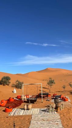 an outdoor seating area in the desert with chairs and tables on top of sand dunes