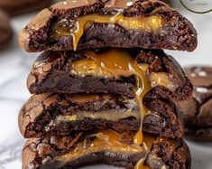 a stack of chocolate cookies with caramel drizzled on them and stacked up