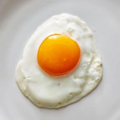 an egg is sitting on top of a white plate