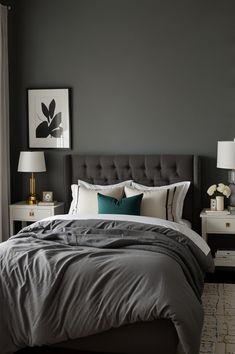 a bedroom with grey walls and white bedding, two lamps on either side of the bed