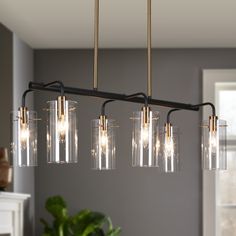 a chandelier with five lights hanging from it's sides in a living room